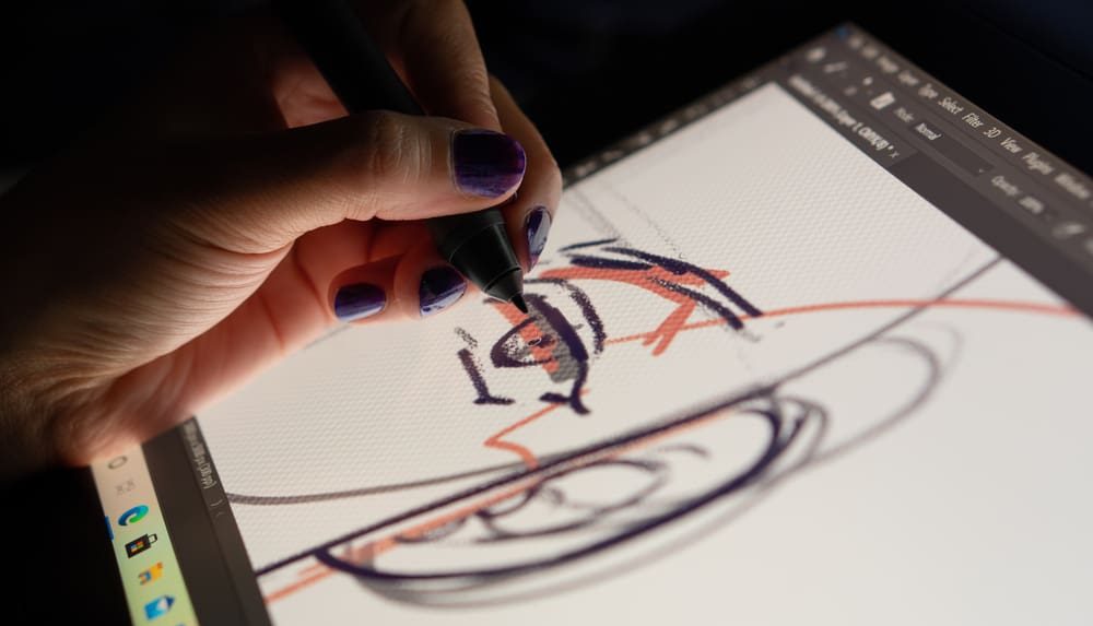 An animator or designer drawing and sketching, involved in the development and creation of graphic characters for animation.