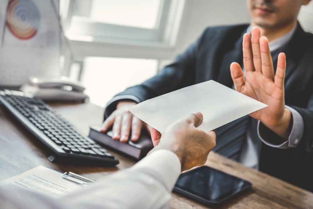 A man in a suit refusing a document related to R&D.