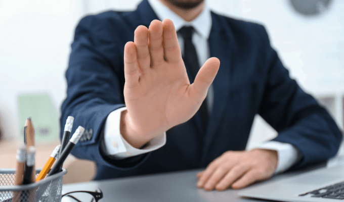 An R&D tax credits professional extends their hand outward in a 'stop' gesture.