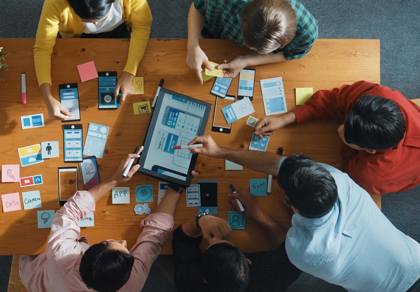 A group of people sitting around a table using a tablet.